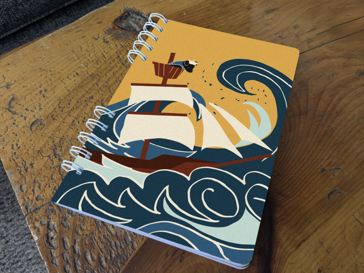 Notebook with illustration of ship sailing through large waves with dog onboard on a table.