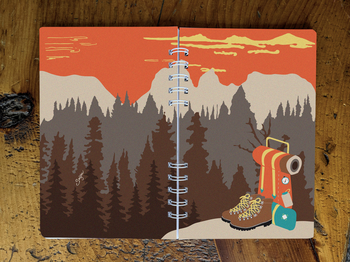 Notebook with illustration of hiking boots and a backpack on table